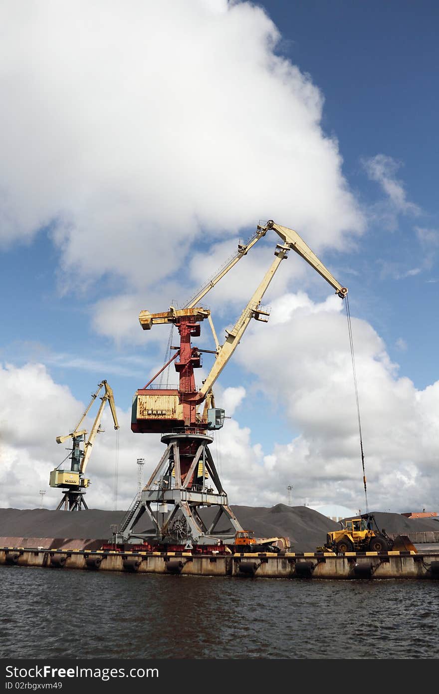 Cranes in harbor working with coal. Cranes in harbor working with coal.