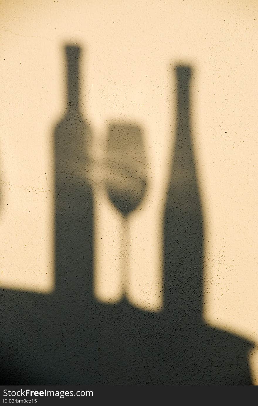 Two vine bottles and a glass as shadows on the wall. Two vine bottles and a glass as shadows on the wall.