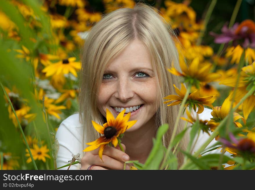 Young woman holding a yellow flower and smiling