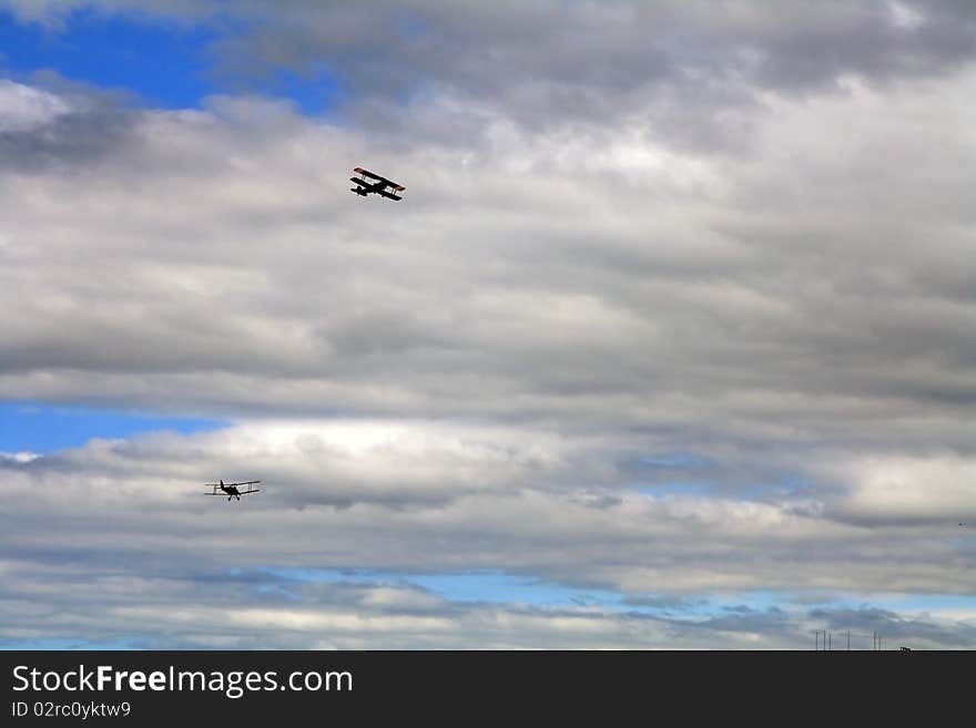 Silhouettes of two airplanes flying in a cloudy sky