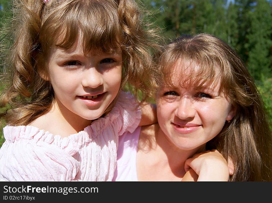 Portrait of the woman and the girl in the summer in park. Portrait of the woman and the girl in the summer in park