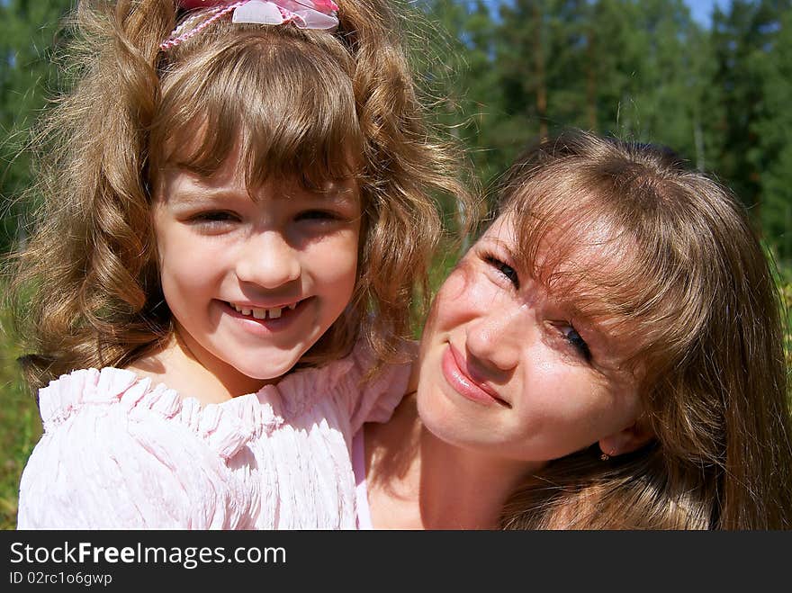 Portrait of the laughing woman and the girl in the summer in park. Portrait of the laughing woman and the girl in the summer in park