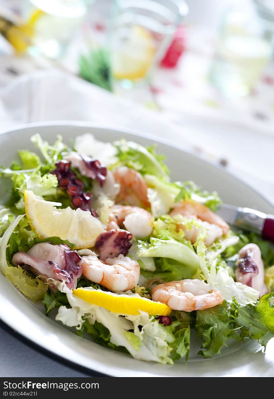 Green salad in a plate with shrimps and octopus