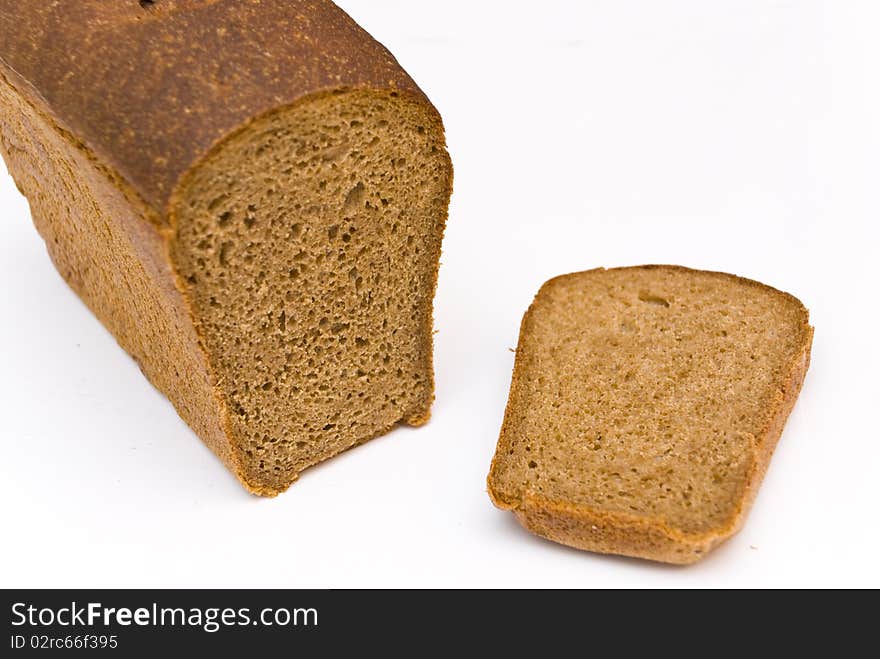 A loaf of rye bread and cut a chunk lying side by side, on a white background. A loaf of rye bread and cut a chunk lying side by side, on a white background