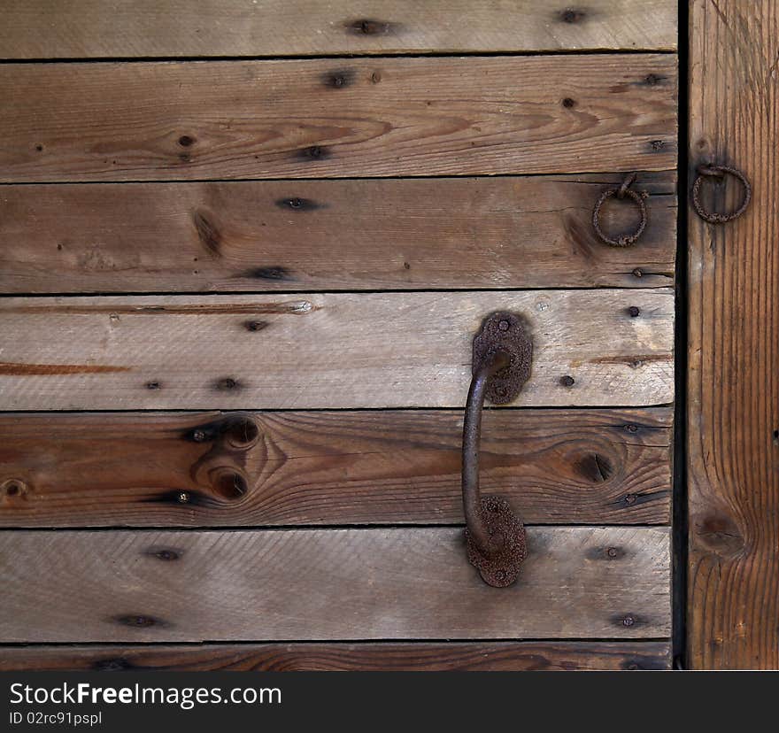 Old wooden doors with the rusty handle and loops