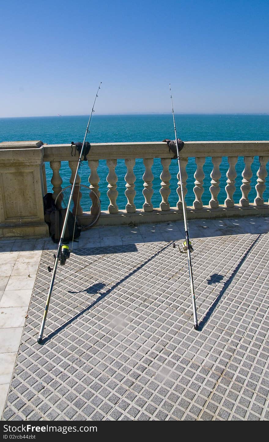 Two fishing roads leaning over the balustrade. Two fishing roads leaning over the balustrade