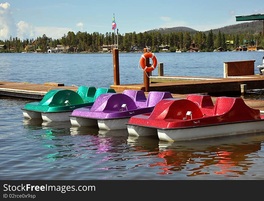 Three colorful paddleboats on a lake in Colorado