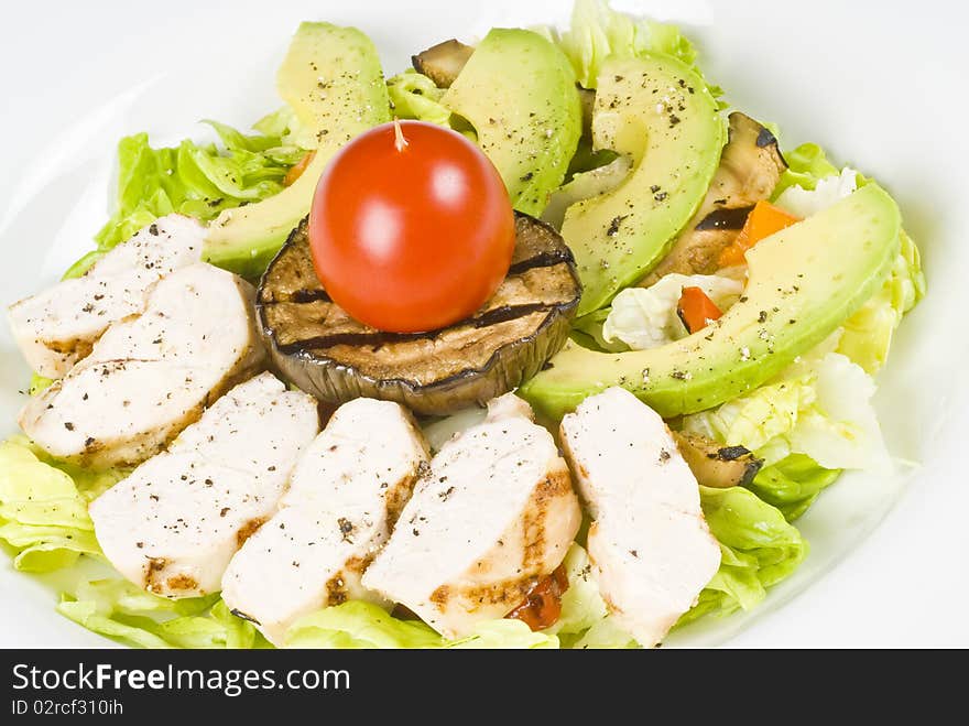 Close-up of grilled chicken breast salad with avocado, Boston lettuce and grilled vegetables.