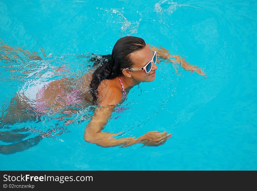 A girl is relaxing in a swimming pool. A girl is relaxing in a swimming pool