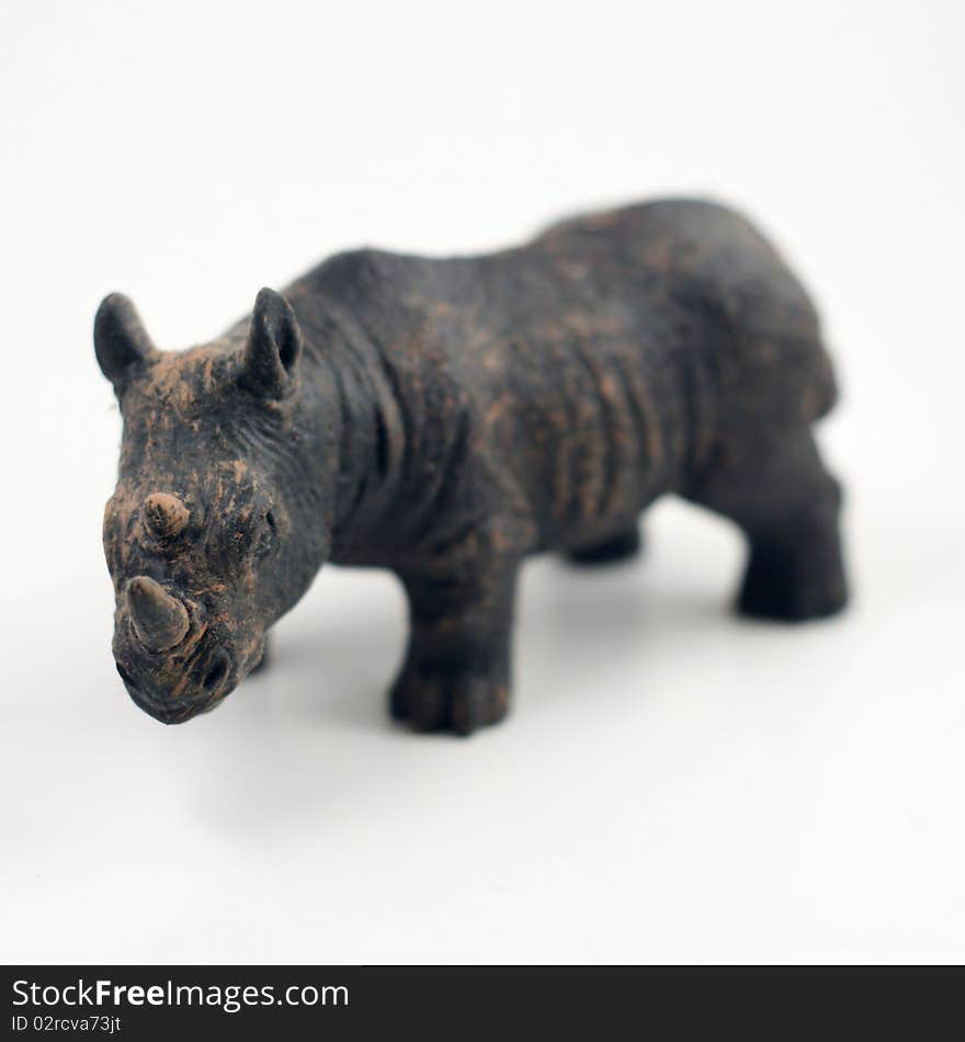 Miniature rhino with sharp focus on horn and body blurred on a white background. Miniature rhino with sharp focus on horn and body blurred on a white background.