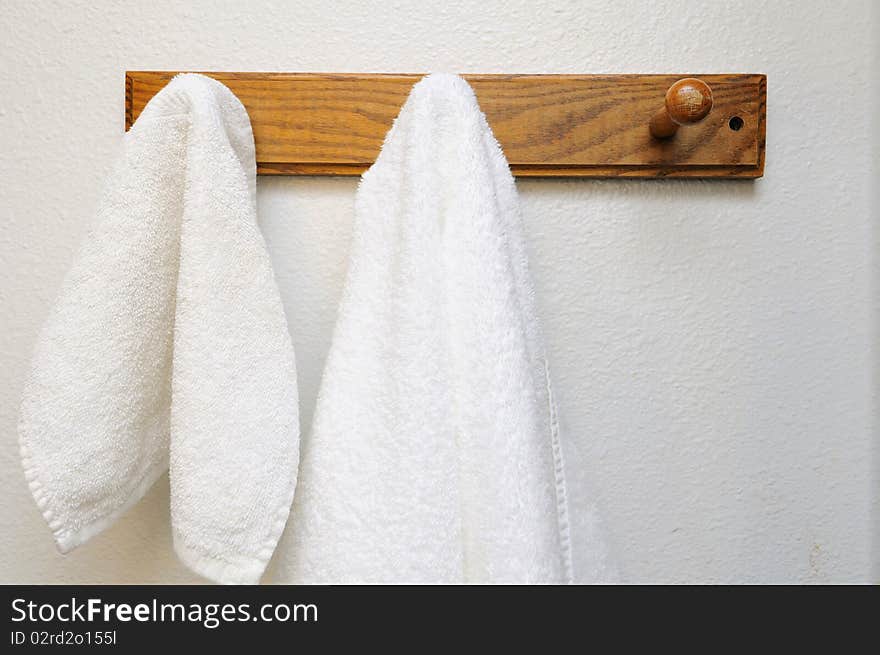 White towels on hook in the bathroom. For health, hygiene, and cleanliness concepts.