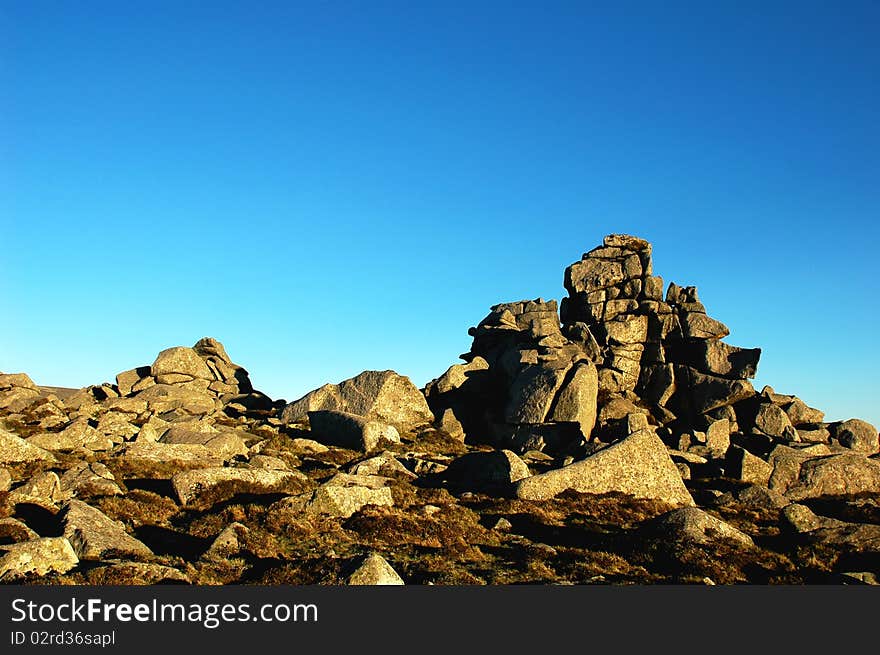 Scenery of huge rocks at the top of mountains with blue skies as backgrounds