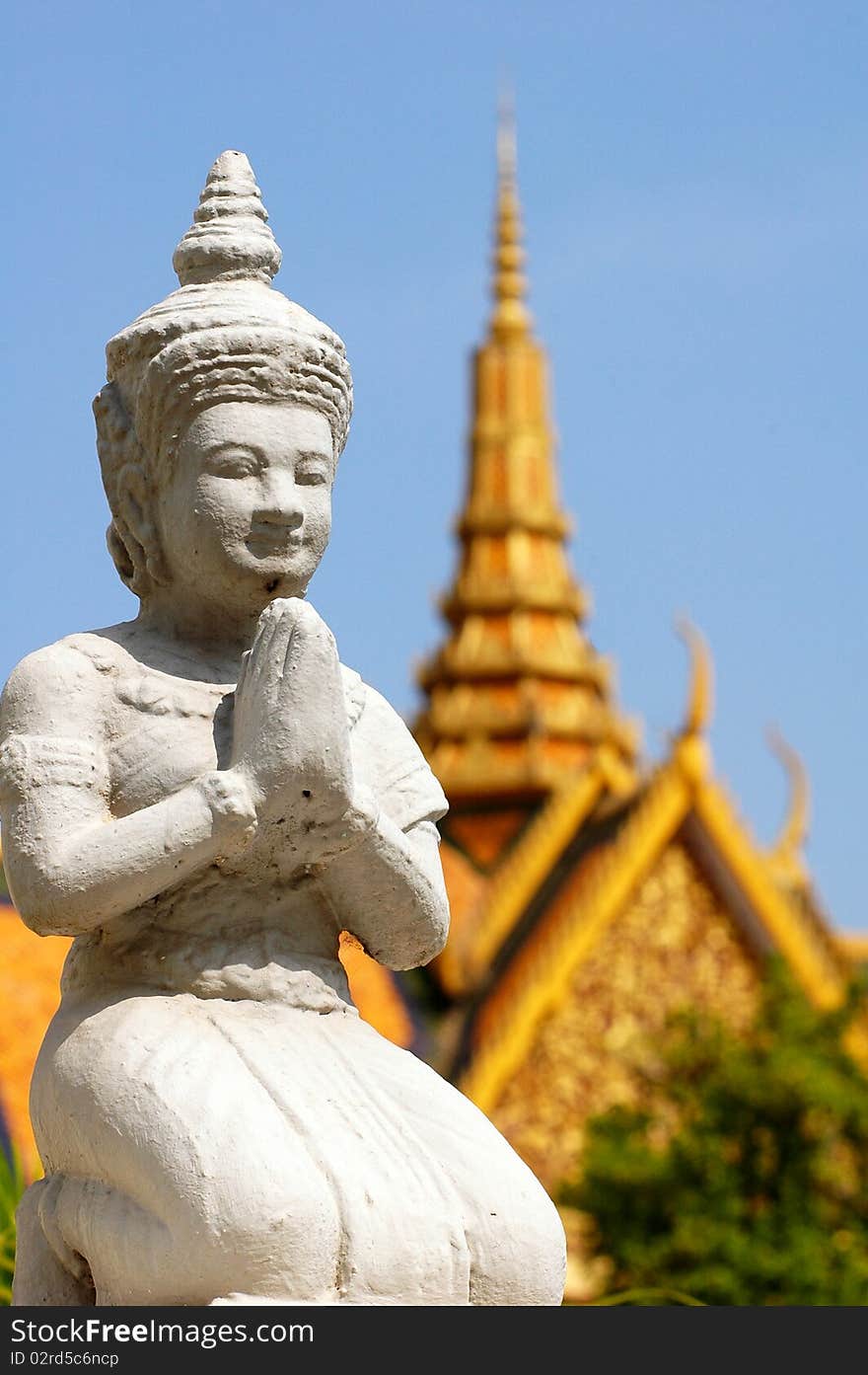 A Stone sculpture of buddha in Phnom Pehn,Cambodia,with the blurred royal palace as background