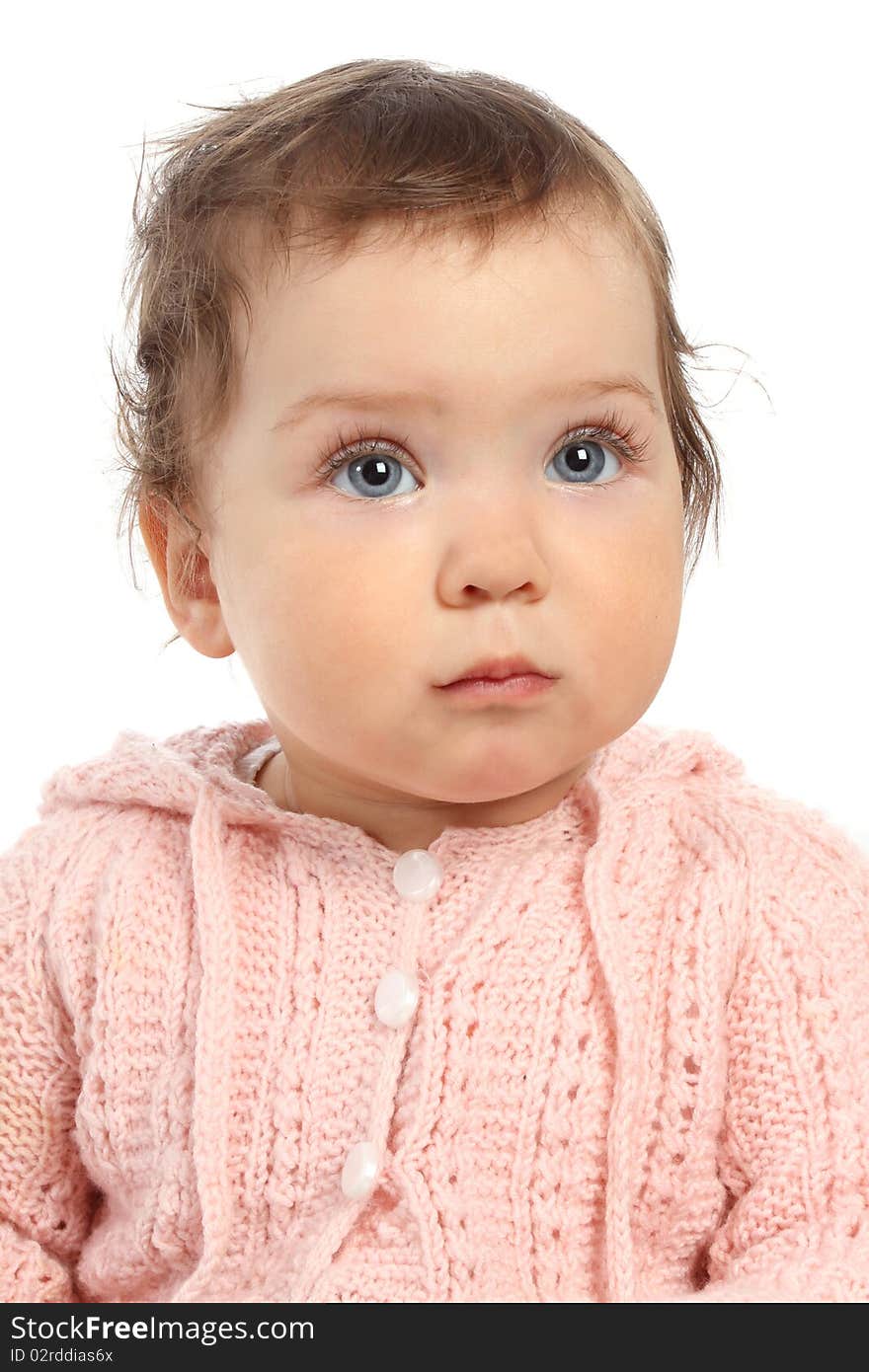 Cute little baby in a pink jumper looks up