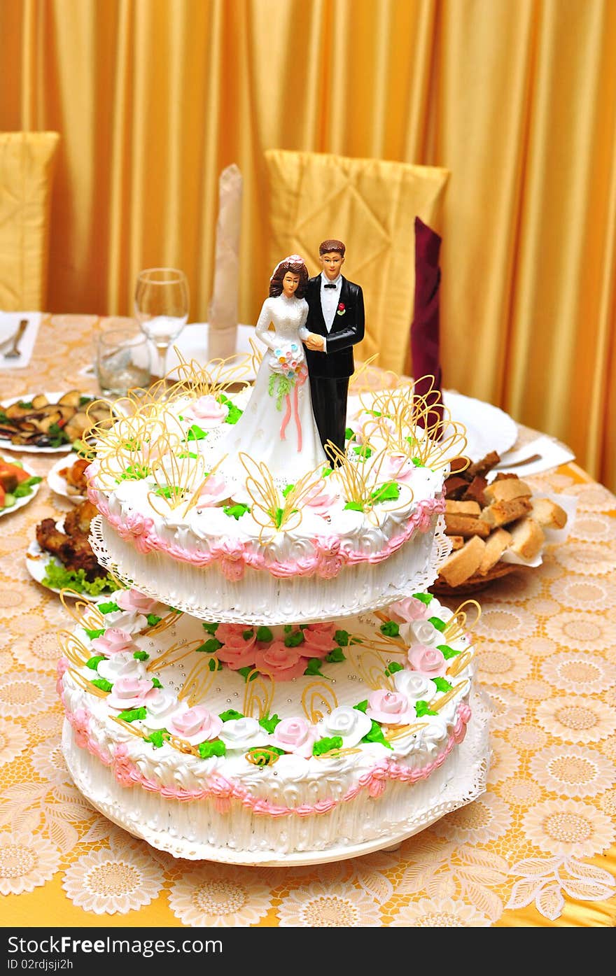 Statues on top of wedding cake on the holiday table