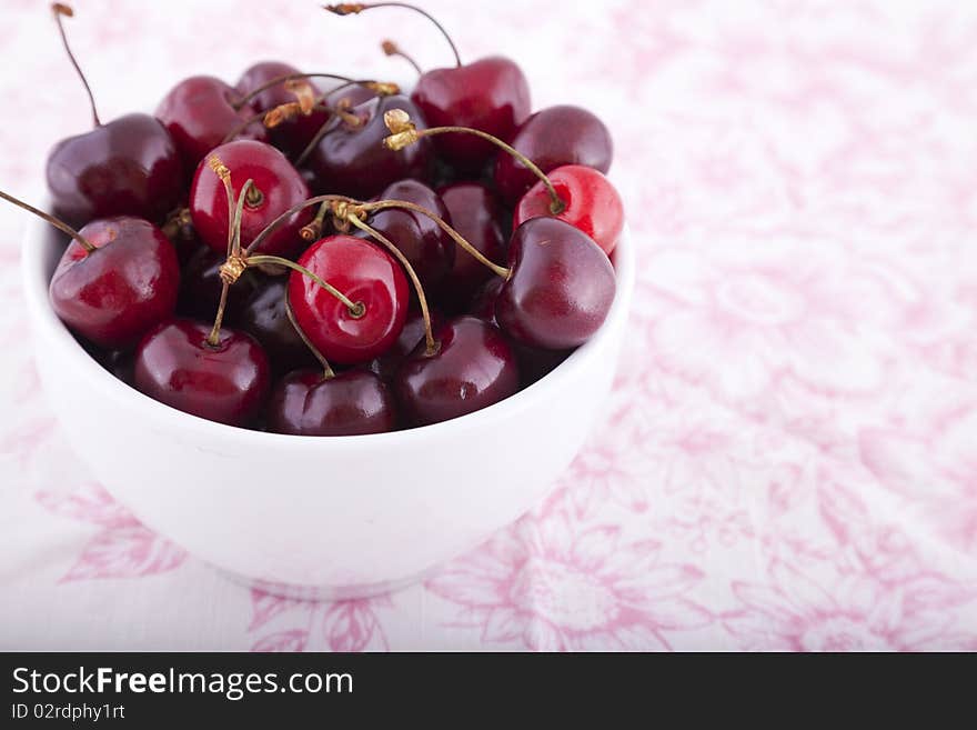 A white bowl of cherries