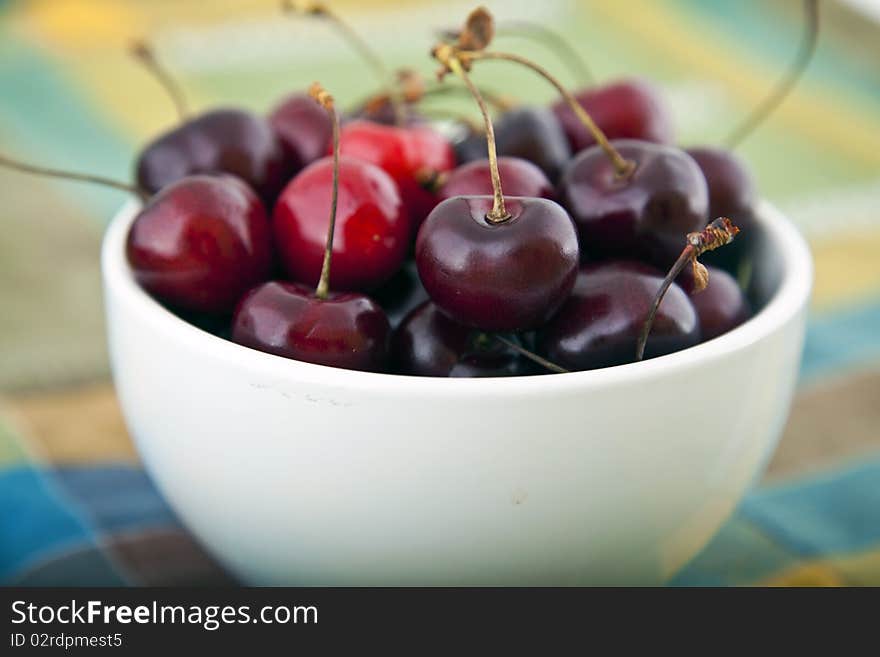 A white bowl of cherries