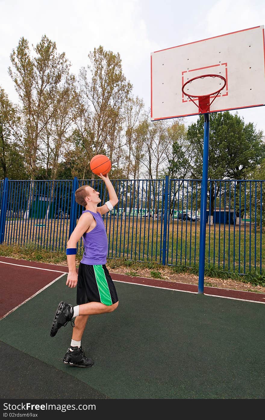 Young men playing street basketball at court playground