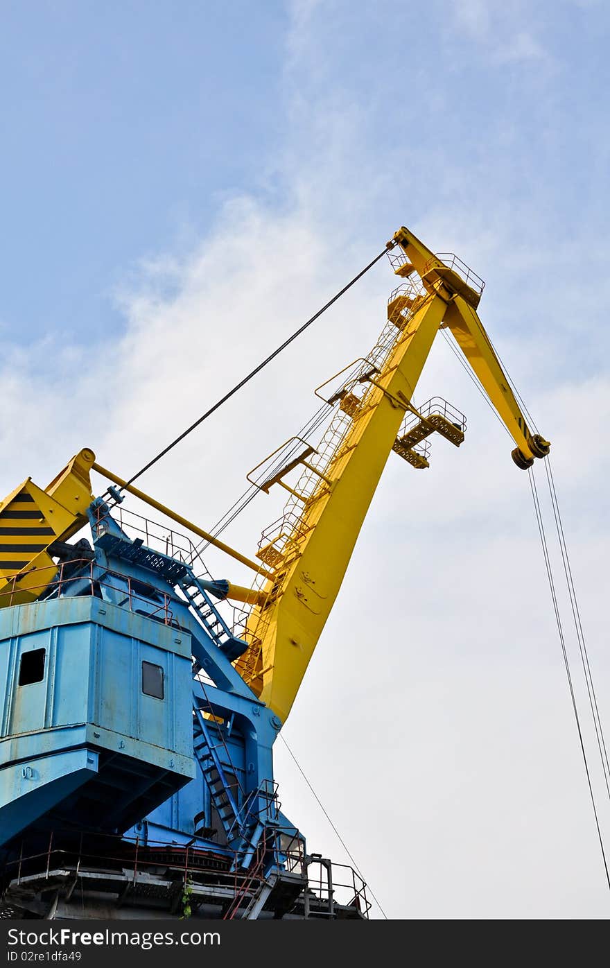 Crane near the mine on the river against blue sky. Crane near the mine on the river against blue sky