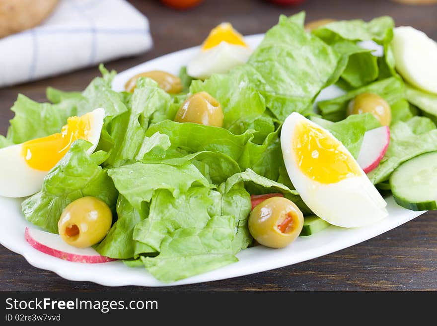 Close up of freshly made salad with lettuce,eggs and olives. Close up of freshly made salad with lettuce,eggs and olives