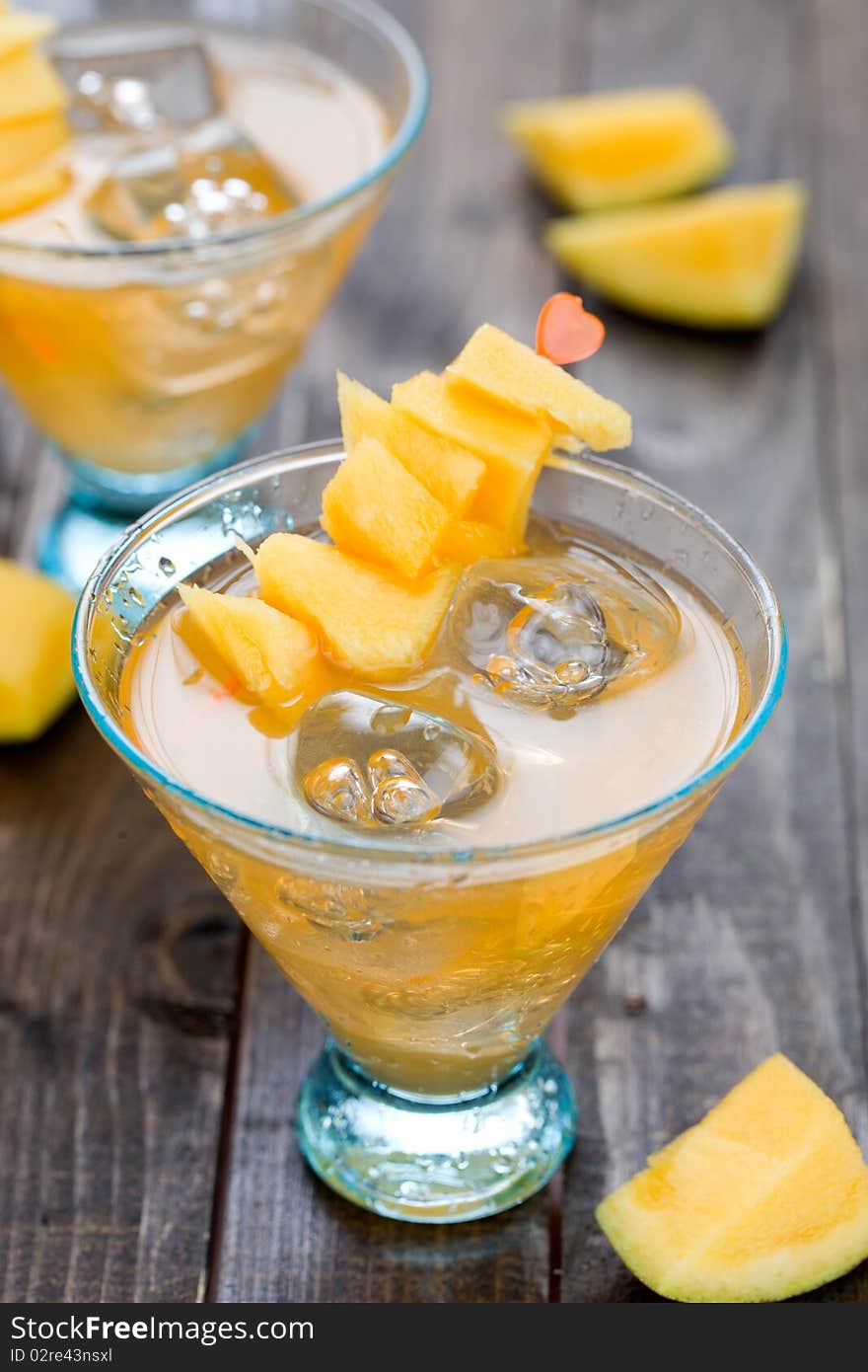 Cocktail with mango fruit on wooden table top. Cocktail with mango fruit on wooden table top