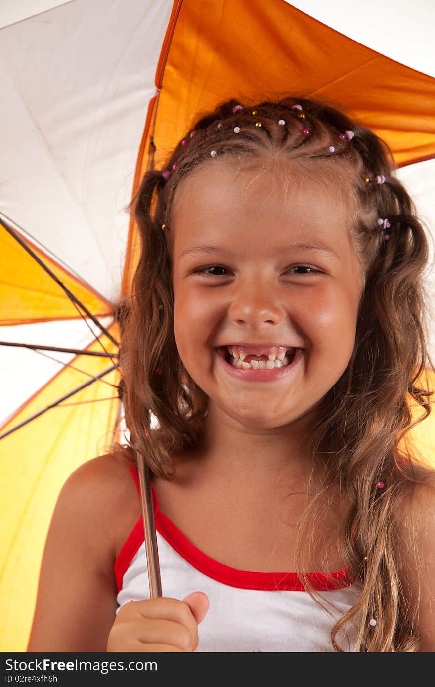 Little girl holding umbrella and showing two missing teeth, studio shot