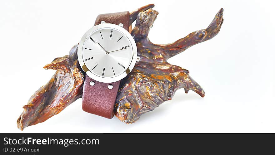 The arm watch with the leather strap on wood in studio