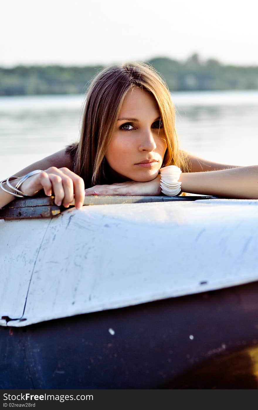 Stunning eyes of the woman looking from the boat on the beach. Stunning eyes of the woman looking from the boat on the beach