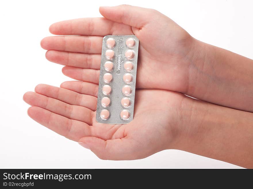 Pink medical pills container on a female hand