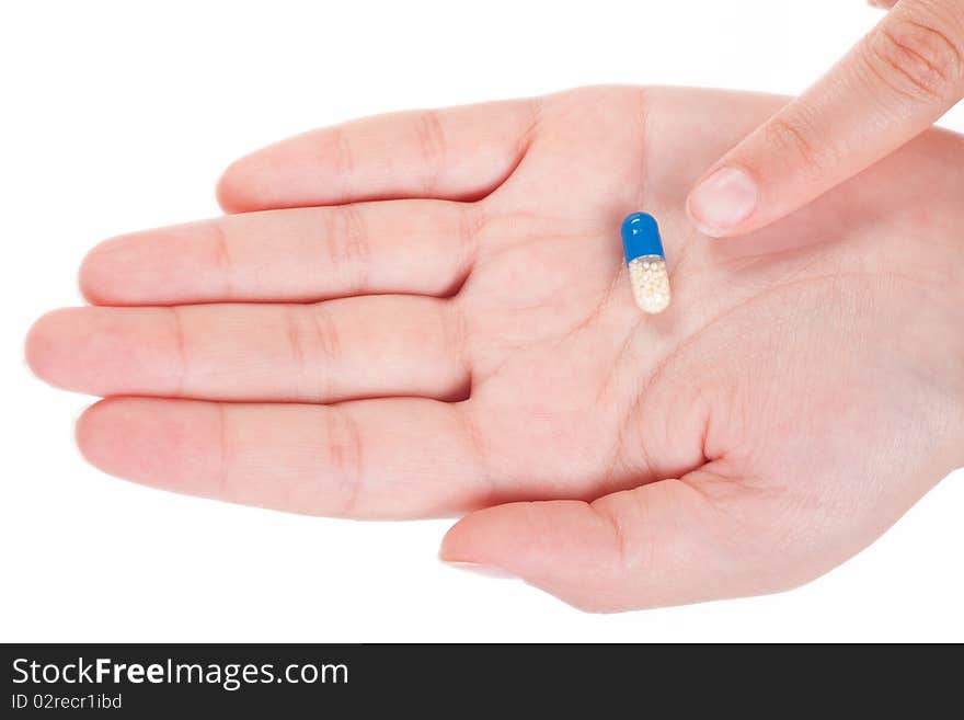 Blue medical capsule in a female hand, isolated on white