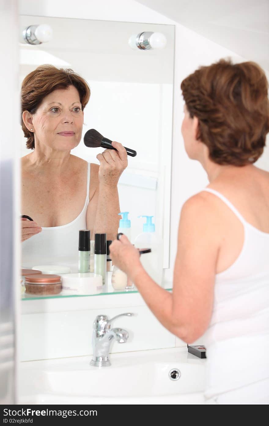 Closeup of senior woman putting makeup on. Closeup of senior woman putting makeup on