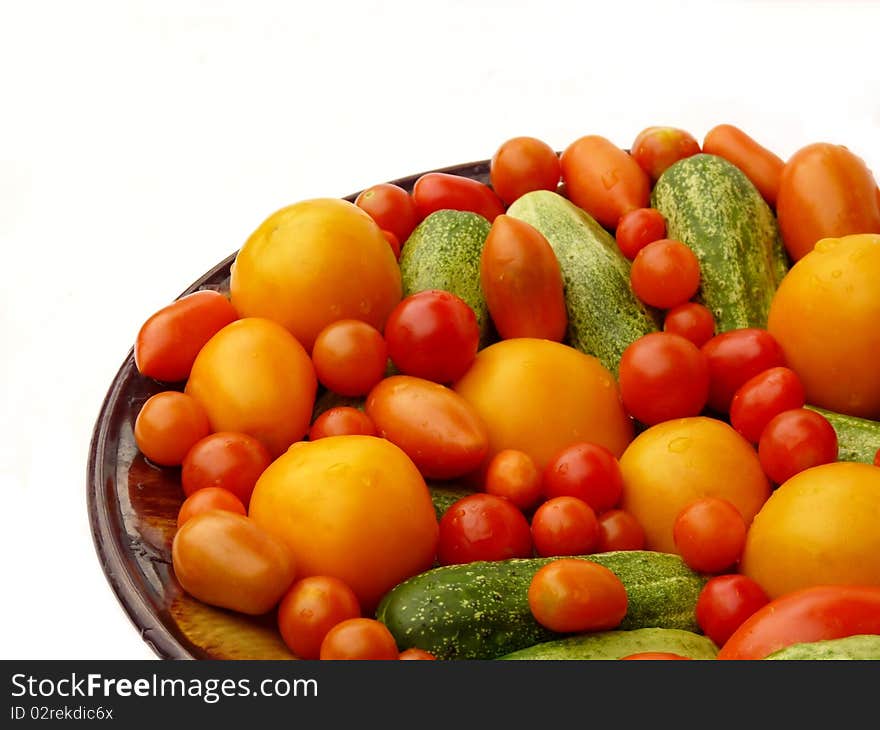 Fresh Tomatoes And Cucumbers On A Plate.