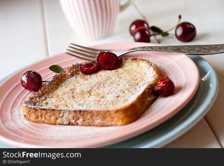 Toasted bread with cherries and powdered sugar