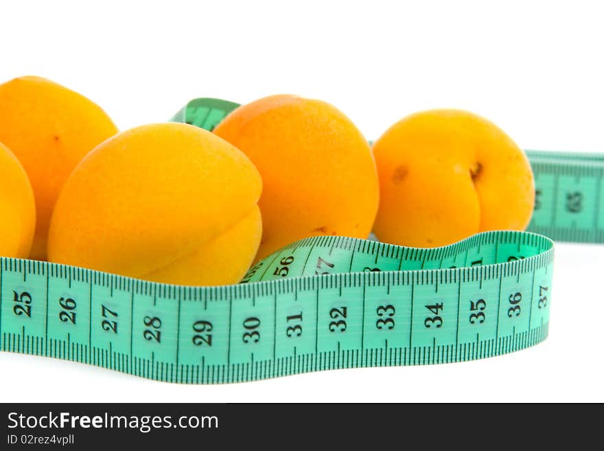 Ripe apricots and measuring tape on white background, concept of healthy eating