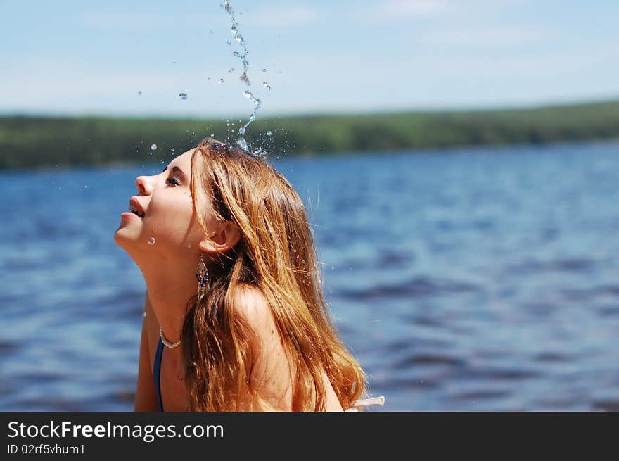 Refreshing water pours a beautiful girl