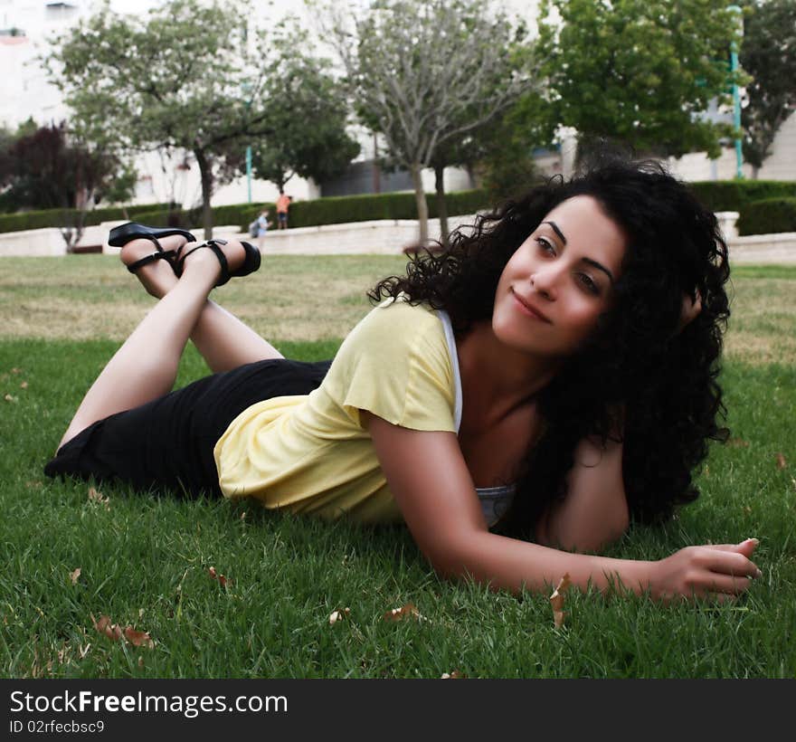 Young happy woman lying on the grass