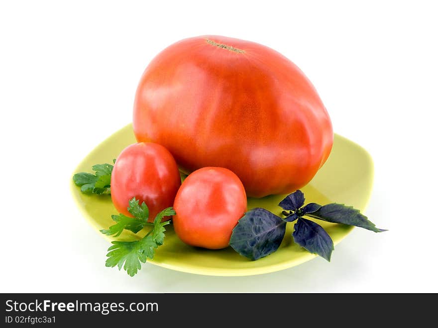 Big tomato with small tomatoes on plate