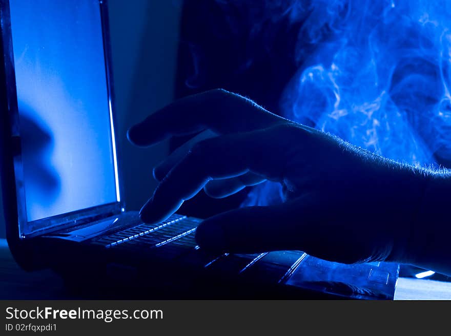 Laptop and human hand on blue background. Laptop and human hand on blue background