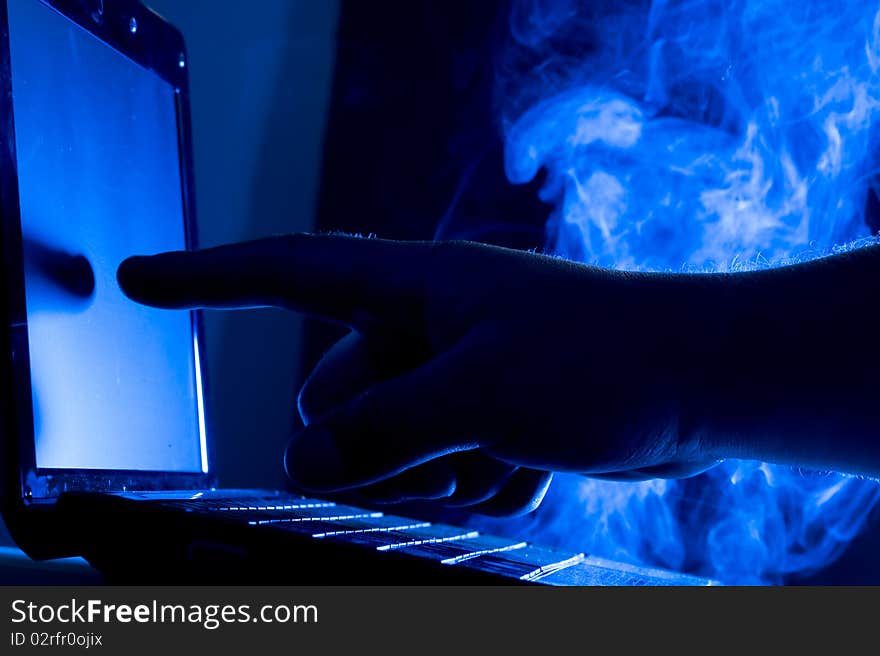 Laptop and human hand on blue background. Laptop and human hand on blue background