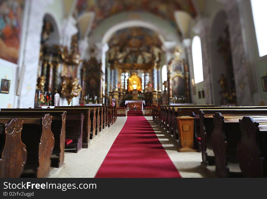 Church interior in Europe with a red carpet leading to the altar.