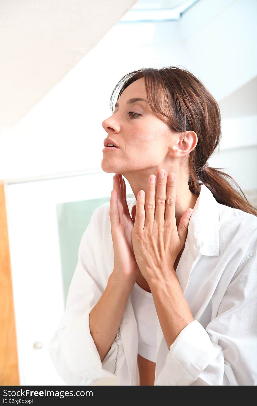 Woman moistuizing her face in the morning. Woman moistuizing her face in the morning