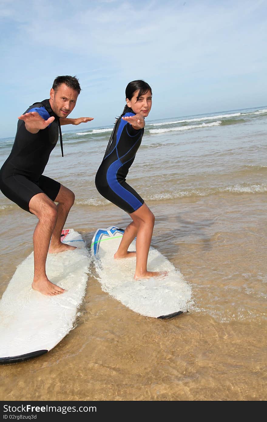 Father and daughter surfing in the ocean. Father and daughter surfing in the ocean