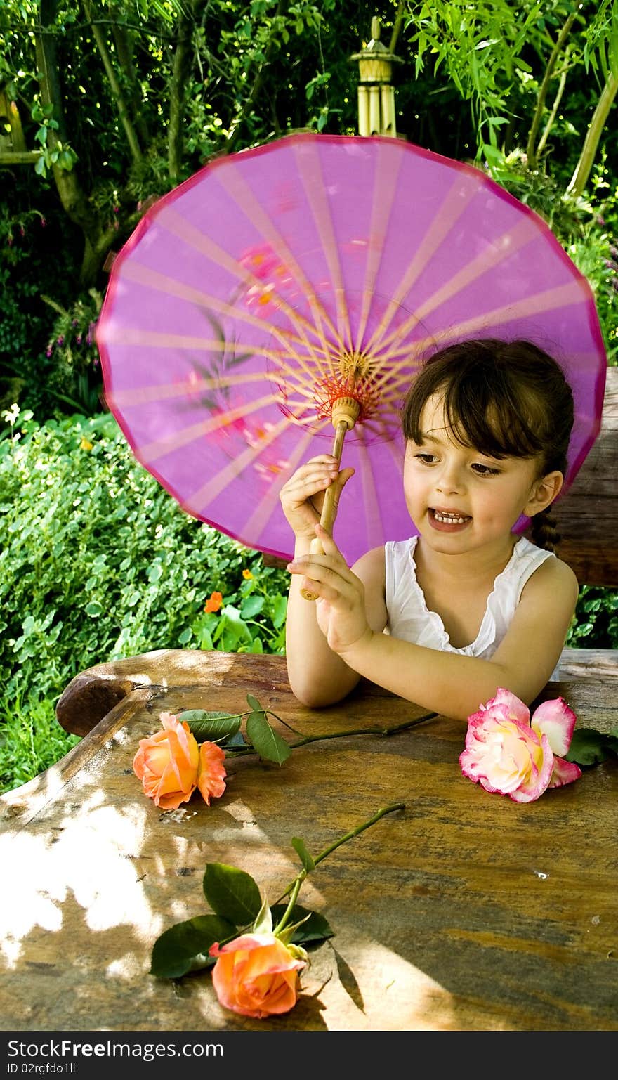 Young girl playing with flowers in a garden on a spring afternoon. Young girl playing with flowers in a garden on a spring afternoon