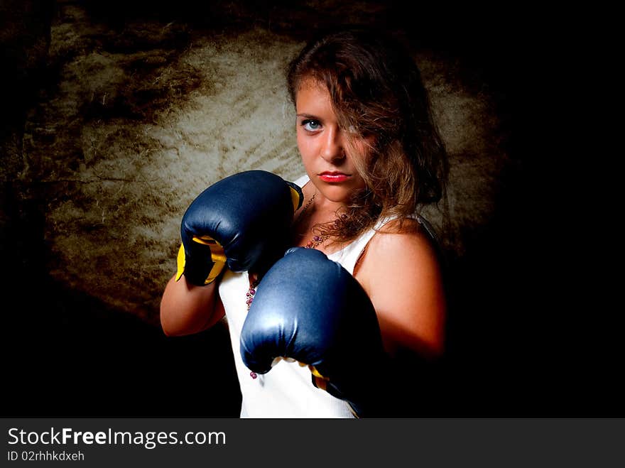 Young aggressive woman in boxing gloves. Young aggressive woman in boxing gloves