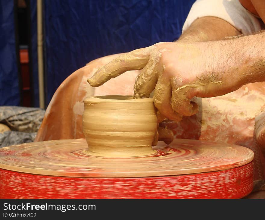 Close-up of hands making pottery on a wheel