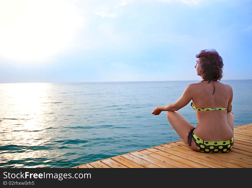 Young women is meditation on the beach