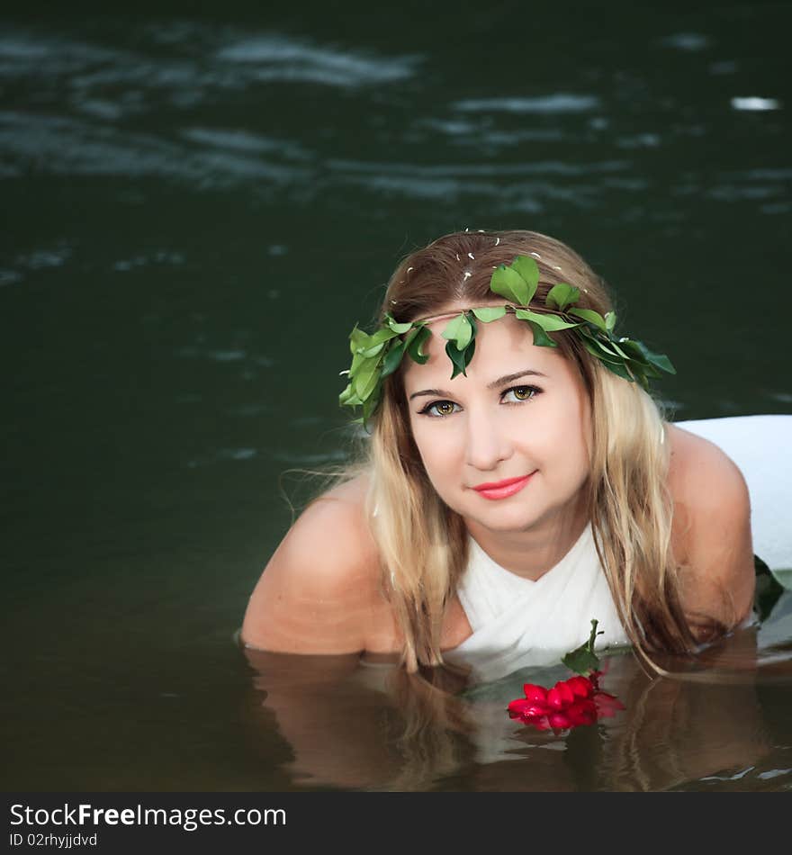 Beautiful woman as a forest nymph on the river