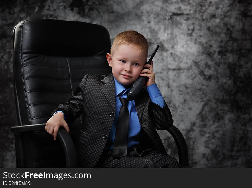 The boy in an armchair with phone. The boy in an armchair with phone