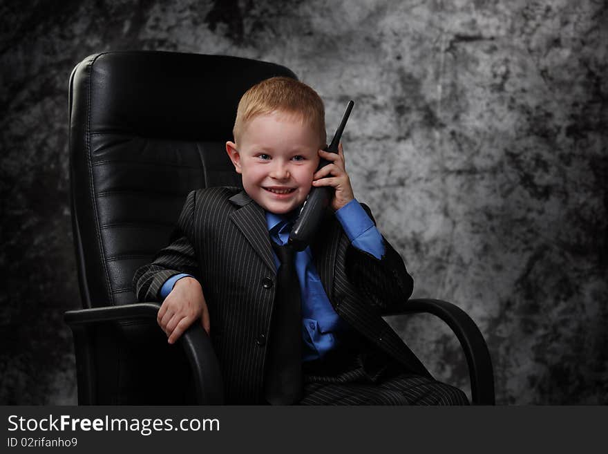 The boy in an armchair with phone. The boy in an armchair with phone