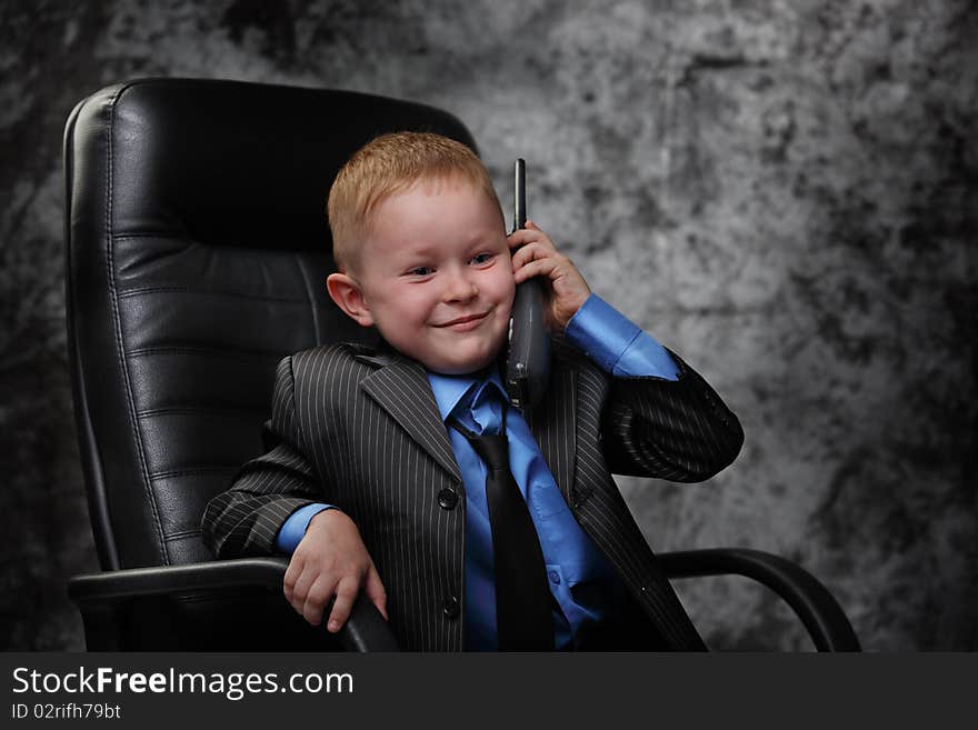 The boy in an armchair with phone. The boy in an armchair with phone